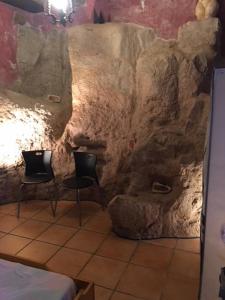 a room with two chairs and a rock wall at Monolocal rural con encanto in Valbona