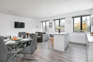 a kitchen and living room with a table and chairs at Reading Kings Road Lodge by Creatick Apartments in Reading