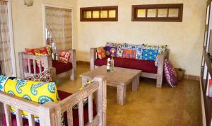 a living room with couches and a table at Footprints House in Diani Beach