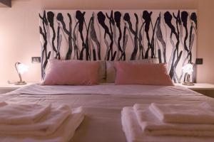 een slaapkamer met een groot bed met een zwart-wit hoofdeinde bij SAN FREDIANO DISTRICT - Apartment in Florence