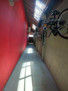 un largo pasillo con una bicicleta colgando de una pared en Morada da Marta en Guarda do Embaú