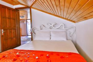 een slaapkamer met een bed met rode bloemen erop bij Kekova Theimussa in Kaleucagız