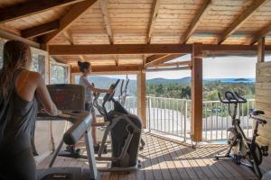 two women exercising on exercise bikes in a gym at Résidence Chiar' Di Luna in Sainte-Lucie de Porto-Vecchio