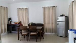 a kitchen with a table with chairs and a refrigerator at Rose's Getaway in General Trias