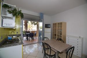 cocina y comedor con mesa, mesa y sillas en Appartamenti La Mer, en San Benedetto del Tronto