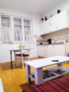 a kitchen with white cabinets and a table in a room at Podgorica Center in Podgorica