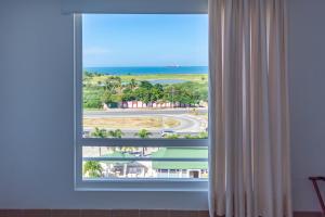 ein Fenster mit Blick auf den Strand und das Meer in der Unterkunft Sanha Plus Hotel in Santa Marta