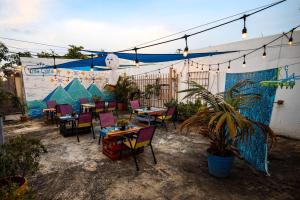 eine Terrasse mit Tischen und Stühlen und ein Wandbild in der Unterkunft Villa Eshta in San Juan