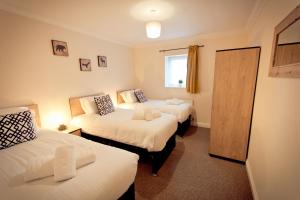 A bed or beds in a room at Top View 2 Bedroom Apartments Plymouth