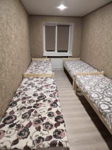 チェベルカにあるUiutnaia kvartira v Teriberkeのベッド3台と窓が備わる客室です。