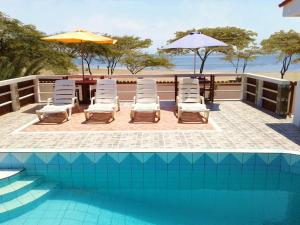 a pool with chairs and a table and umbrella at La Perla in Los Órganos