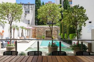 a balcony with a pool and chairs and trees at Argenta Suites Belgrano in Buenos Aires