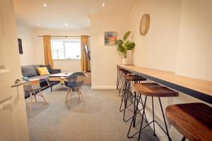 a kitchen and living room with a counter and chairs at Top View 2 Bedroom Apartments Plymouth in Plymouth