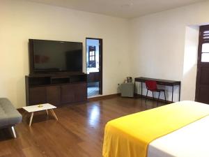 a living room with a flat screen tv and a bed at Casa de Balcones in Garzón