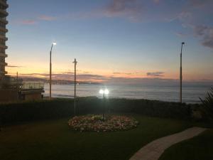 - une vue sur l'océan au coucher du soleil avec une horloge fleurie dans l'établissement Muelle Vergara view, à Viña del Mar