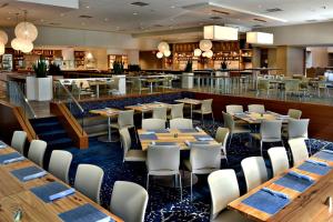 um restaurante com mesas e cadeiras e um bar em JB Duke Hotel em Durham