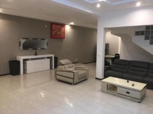 a living room with a couch and a tv at SALY - Villa Kage 6 chambres -Clim-Wifi-Eau chaude-Billard-Babyfoot-Ping pong-Canal - ELECTRICITE NON COMPRISE in Sali Nianiaral