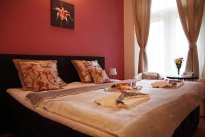 a bedroom with a large bed with red walls at Penzion Alfa Poděbrady in Poděbrady