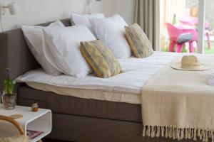 a bed with pillows and a hat on top of it at Studio Zonnehoek Schoorl in Schoorl