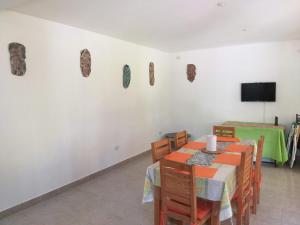 uma sala de jantar com mesa e cadeiras e uma televisão em Casa quinta En Tortuguitas em Tortuguitas