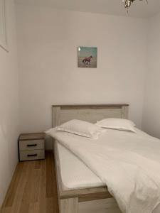 łóżko z białą pościelą i zdjęciem na ścianie w obiekcie Sunrise Apartment w Sybinie