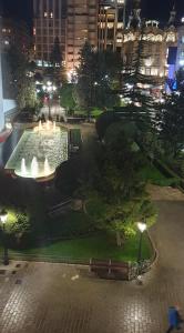 un parque con una fuente en una ciudad por la noche en ALTOZANO en Albacete