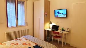 een kamer met een bureau, een bed en een computer bij Bed And Breakfast Corticella 24 in Bologna