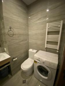 a bathroom with a toilet and a washing machine at Bright Studio in "New Gudauri" in Gudauri
