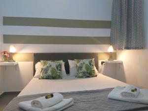 a bedroom with a bed with towels on it at City Square Apartment in Chania