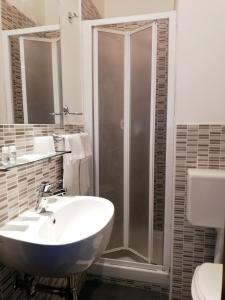 een badkamer met een witte wastafel en een douche bij Hotel Dover in Milaan