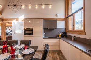a kitchen and dining room with a table and chairs at Chalet Hirondelle Morzine - by EMERALD STAY in Morzine