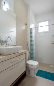 a bathroom with a sink and a toilet and a shower at Cobertura com Jacuzzi privativa in Governador Celso Ramos