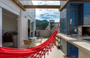 a balcony with a red hammock on a house at Cobertura com Jacuzzi privativa in Governador Celso Ramos