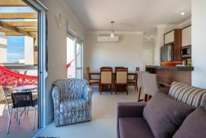 a living room with a couch and chairs and a kitchen at Cobertura com Jacuzzi privativa in Governador Celso Ramos +14 photos