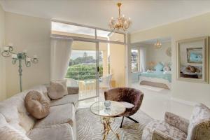 Una sala de estar con un sofá, una mesa y una cama. en L`Azur : Elegant Apartment with Sea View, en Wilderness 24 fotos más