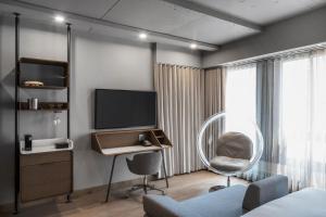 モントリオールにあるオテル ル ジェルマン モントリオールのテレビ、椅子、デスクが備わる客室です。