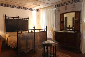 a bedroom with a bed and a dresser and a mirror at Relais San Desiderio in Calliano