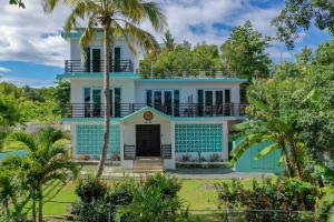 ein blau-weißes Haus mit einer Palme in der Unterkunft The Beach Pad in Rincon
