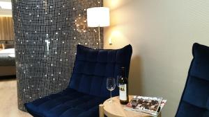 uma cadeira azul sentada ao lado de uma mesa com um copo de vinho em B&B Centrum Hengelo em Hengelo