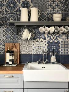 a kitchen with a sink and blue and white tiles at Hvammsvík Nature Resort in Kjósahreppur