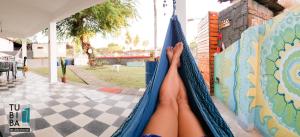 a persons legs in a hammock on a wall at Tubiba Hostel in Tamandaré