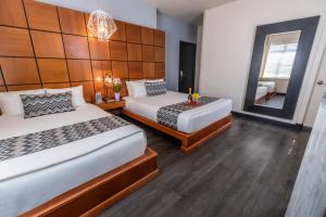 Habitación de hotel con 2 camas y espejo en Chesterfield Hotel & Suites, en Miami Beach