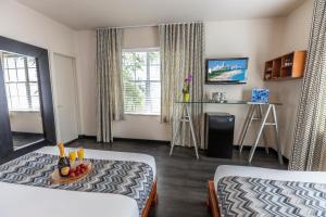 Habitación con 2 camas y mesa con TV. en Chesterfield Hotel & Suites, en Miami Beach