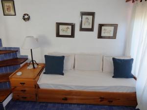 uma cama num quarto com almofadas azuis e brancas em Triplex N° 2 en San Bernardo em San Bernardo