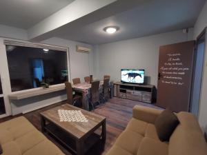 a waiting room with a couch and a table and a tv at Panorama Rooms in Sofia