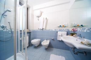 La salle de bains bleue et blanche est pourvue de toilettes et d'un lavabo. dans l'établissement Hotel Sirio, à Lido di Camaiore