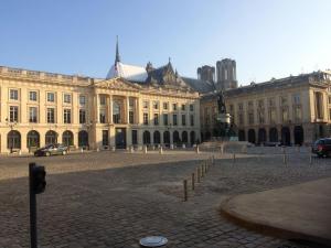 een groot gebouw met een plein ervoor bij LE NID DES ROIS, à 2 pas de la Cathédrale in Reims