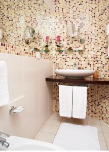 bagno con lavandino e servizi igienici con asciugamani di Hotel Sirio a Lido di Camaiore