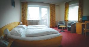 una camera da letto con un letto grande e una sedia di Hotel Post a Ramsau am Dachstein