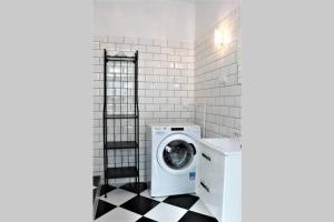 a washing machine in a bathroom with a black and white floor at Corner 5 I Old Town I Cosy Studio in Krakow